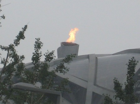 Olympische vlam Beijing boven Bird's Nest
